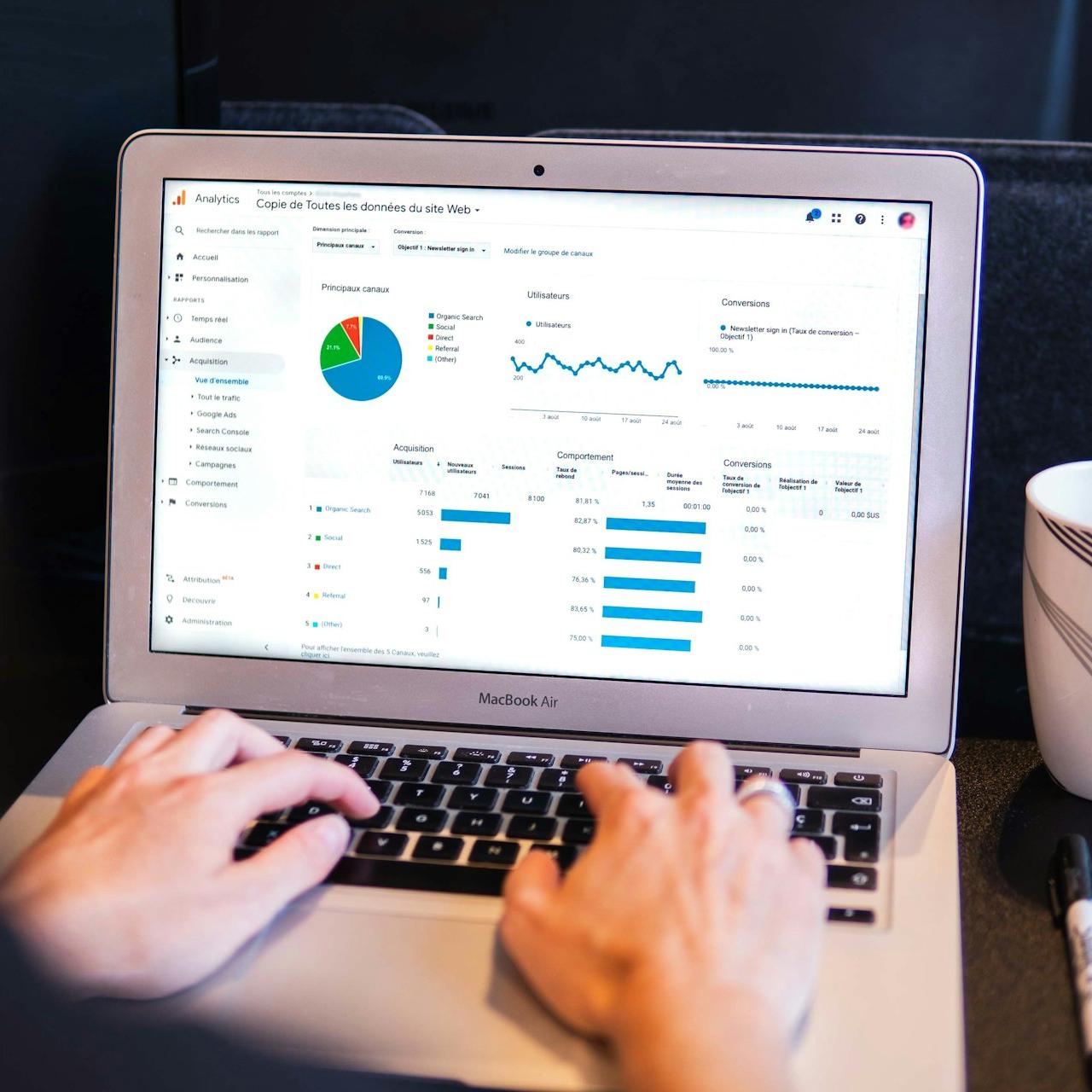 person using macbook pro on black table